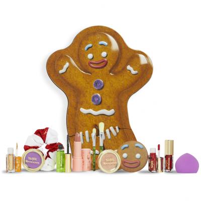 Makeup Revolution London Shrek Gingy 12 Days Advent Calendar Dárková kazeta oční stíny 2 ks + rozjasňovač 1 ks + lesk na rty 2 ks + rtěnka 1 ks + tvářenka 1 ks + gel na obočí 1 ks + štětec 2 ks + houbička na make-up 1 ks + zrcátko 1 ks + gumička na vlasy 1 ks